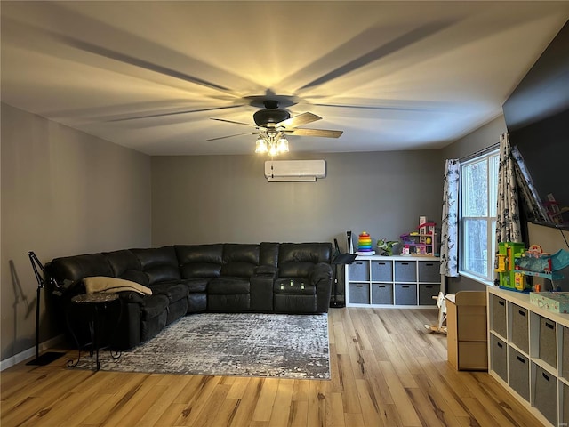 living room with ceiling fan, wood finished floors, and a wall mounted AC