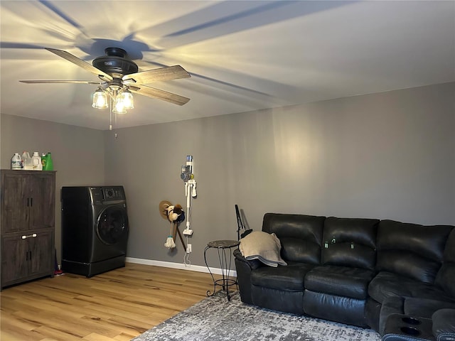 living room with washer / dryer, light wood-style floors, baseboards, and ceiling fan