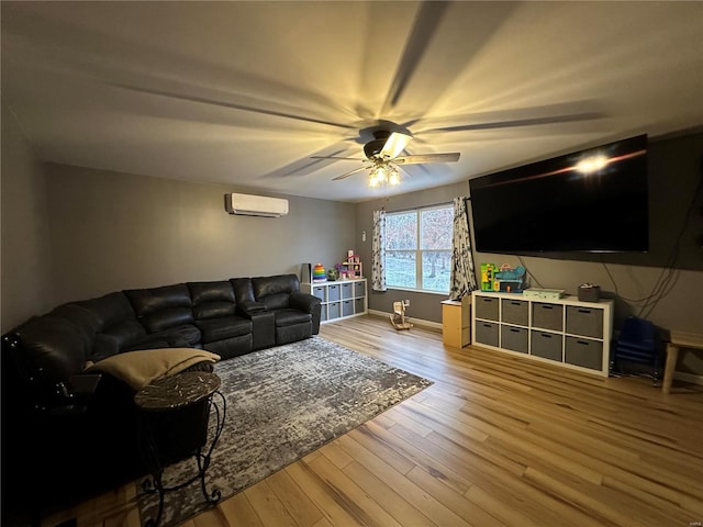 living room with an AC wall unit, ceiling fan, light wood-style flooring, and baseboards