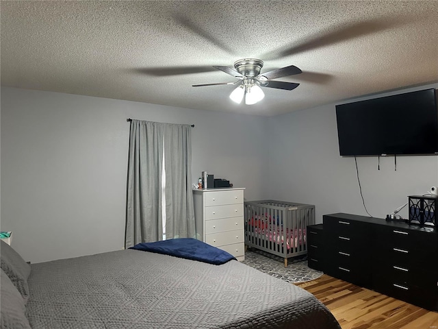 bedroom featuring a ceiling fan, a textured ceiling, and wood finished floors