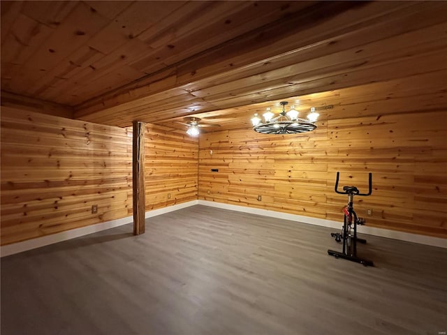 interior space with a notable chandelier, wood walls, wood finished floors, wood ceiling, and baseboards