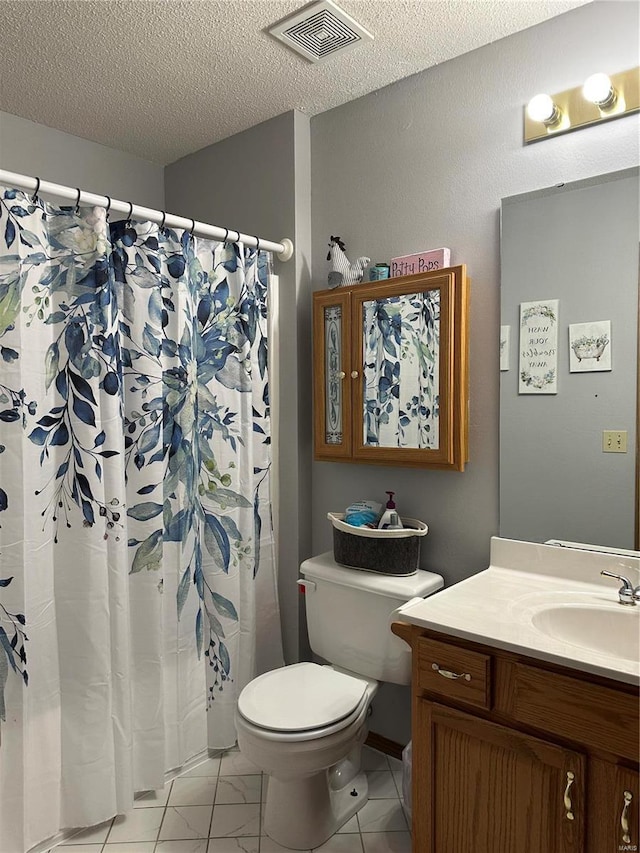 bathroom featuring a textured ceiling, toilet, vanity, visible vents, and marble finish floor