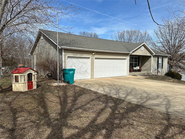 exterior space featuring driveway, an attached garage, and a shingled roof