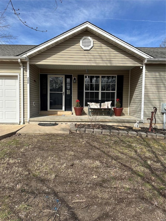 ranch-style house featuring covered porch, a shingled roof, and an attached garage