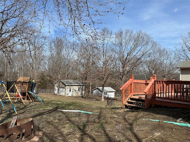 view of yard with an outbuilding, a deck, and a playground