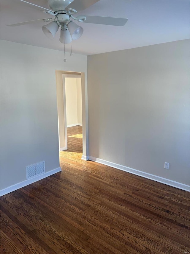 spare room with dark hardwood / wood-style flooring and ceiling fan