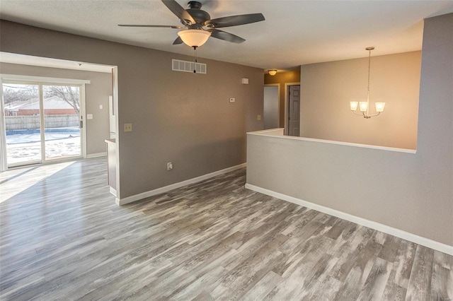 unfurnished room featuring wood-type flooring and ceiling fan with notable chandelier