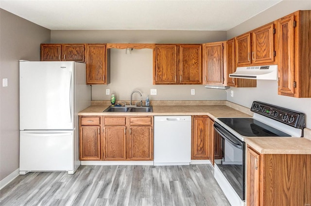 kitchen with sink, white appliances, and light hardwood / wood-style floors