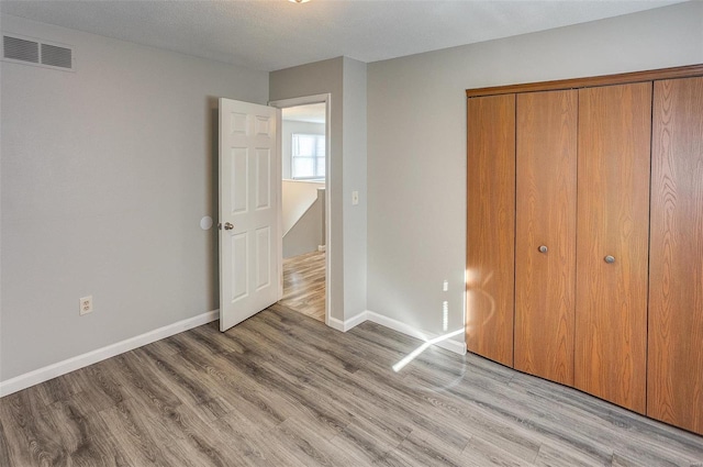 unfurnished bedroom featuring light hardwood / wood-style floors and a closet