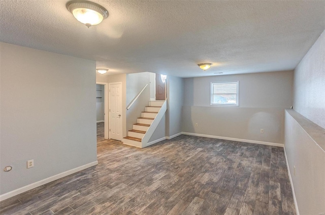 basement featuring dark hardwood / wood-style floors and a textured ceiling