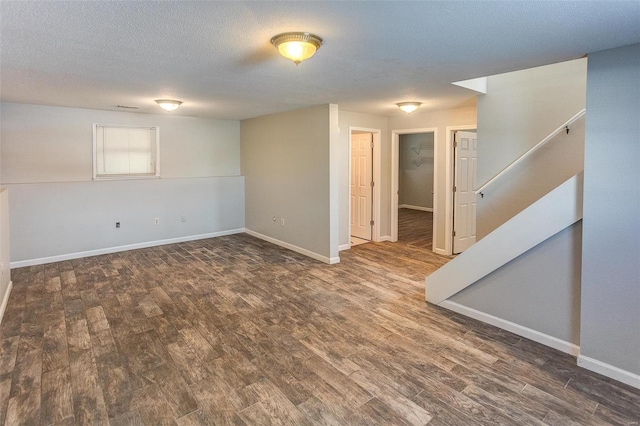 basement featuring dark hardwood / wood-style flooring and a textured ceiling