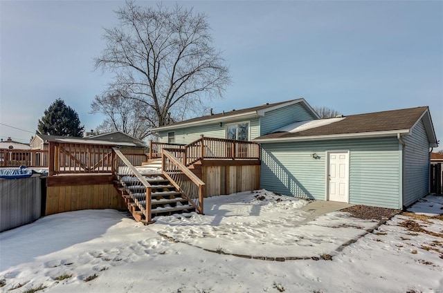 snow covered rear of property with a wooden deck