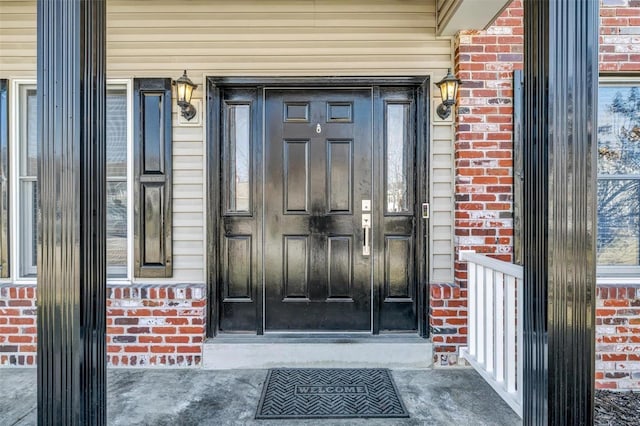 entrance to property featuring brick siding