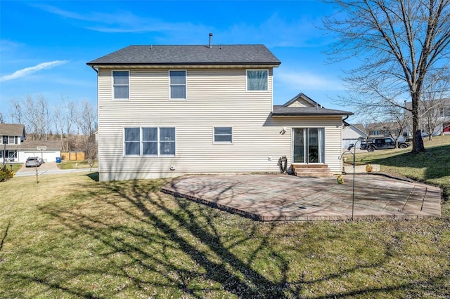 back of house with entry steps, roof with shingles, a lawn, and a patio