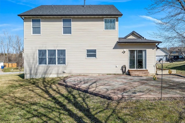 back of house with entry steps, a yard, and a patio