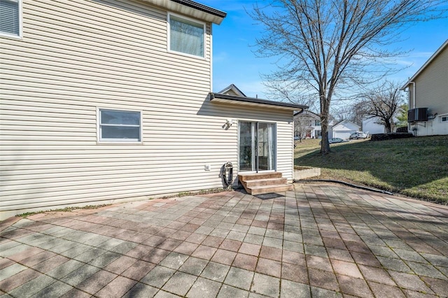 exterior space with entry steps, a patio, a lawn, and central air condition unit