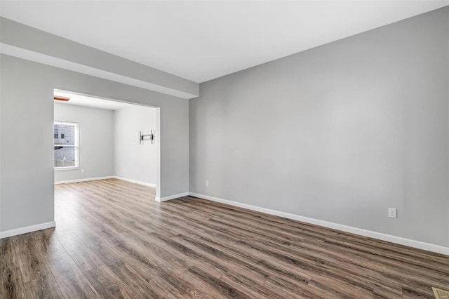 empty room featuring baseboards and wood finished floors