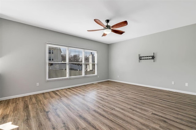 spare room featuring a ceiling fan, baseboards, and wood finished floors