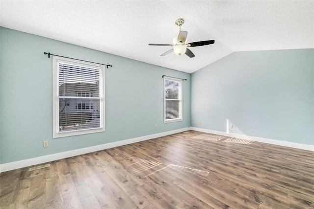 unfurnished room featuring lofted ceiling, wood finished floors, and baseboards