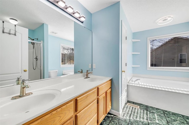 full bathroom featuring a stall shower, double vanity, a sink, and a bath