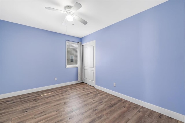 empty room featuring ceiling fan, wood finished floors, and baseboards