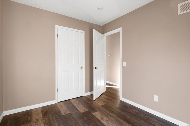 unfurnished bedroom featuring dark hardwood / wood-style floors