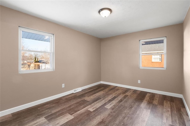 empty room with dark hardwood / wood-style flooring