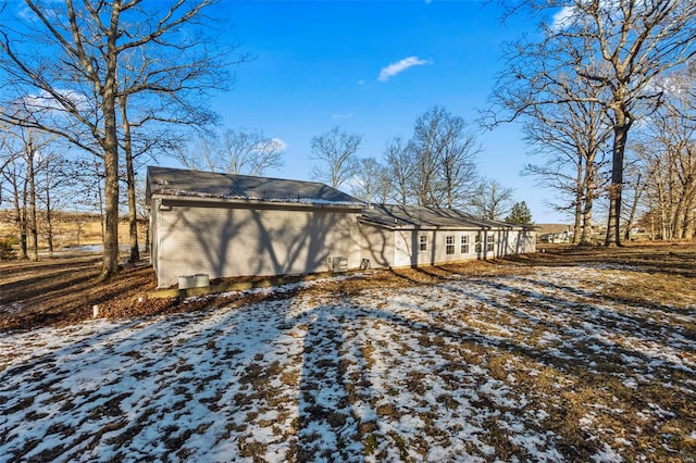 view of snow covered back of property