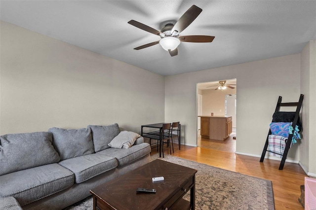 living room with light hardwood / wood-style floors and ceiling fan