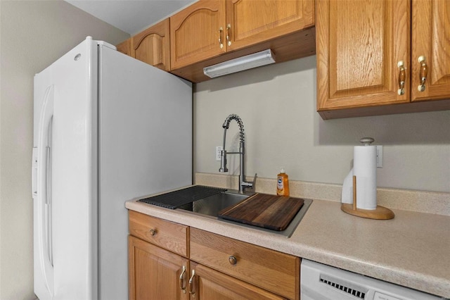 kitchen featuring white refrigerator with ice dispenser, sink, and dishwasher