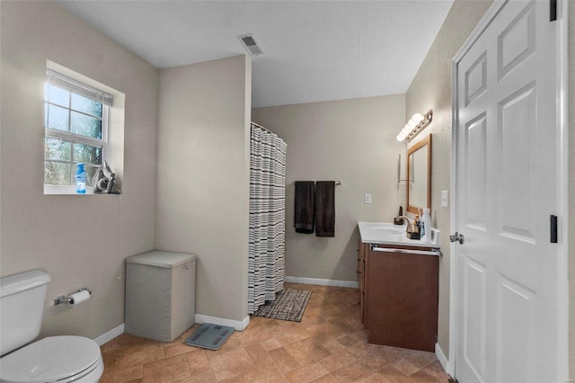 bathroom featuring vanity, walk in shower, and toilet