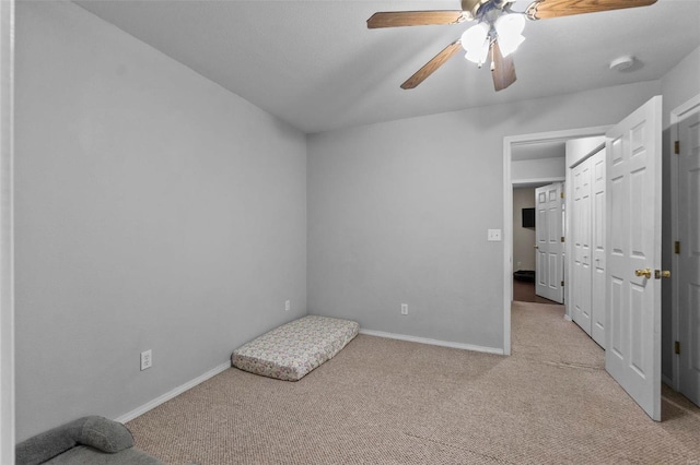 unfurnished bedroom featuring light carpet, ceiling fan, and a closet