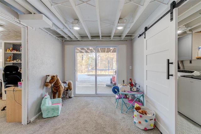 playroom featuring washer / dryer, a barn door, and carpet