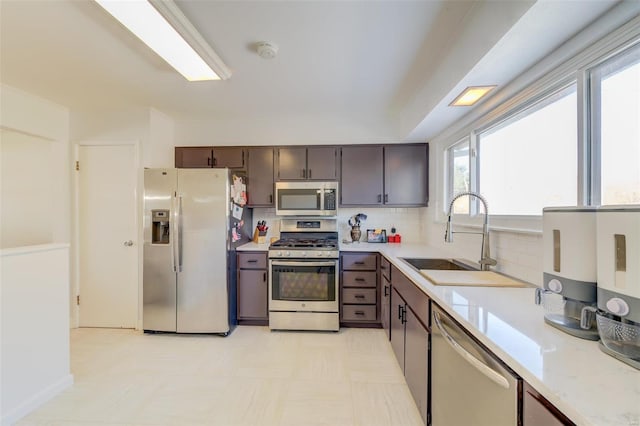 kitchen with appliances with stainless steel finishes, sink, dark brown cabinets, and decorative backsplash