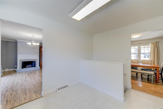 unfurnished room with an inviting chandelier and a tiled fireplace