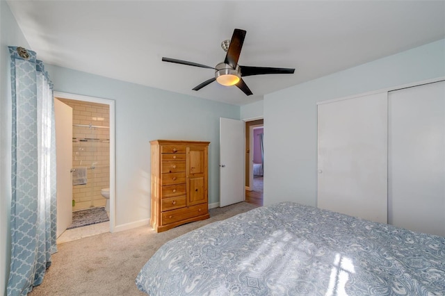 carpeted bedroom with ensuite bath, ceiling fan, and a closet