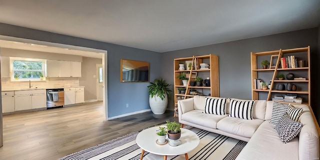 living room featuring sink and light hardwood / wood-style flooring