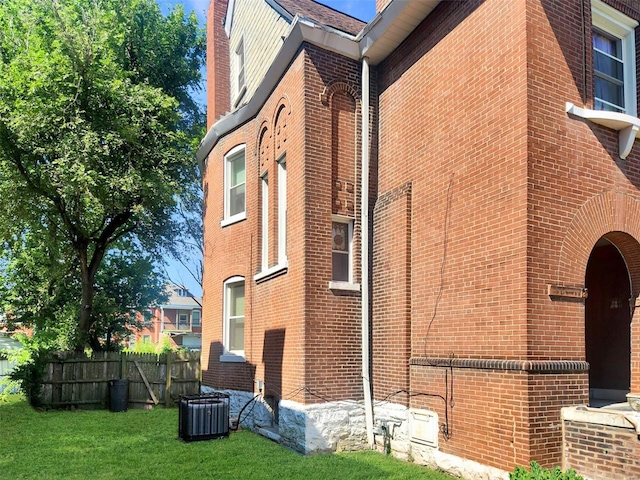 view of side of home with a yard and central air condition unit