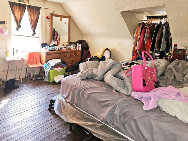 bedroom with lofted ceiling, hardwood / wood-style floors, and a closet