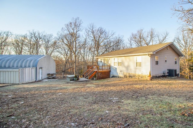 view of side of home with cooling unit and an outbuilding