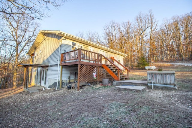 back of property featuring stairway and a wooden deck