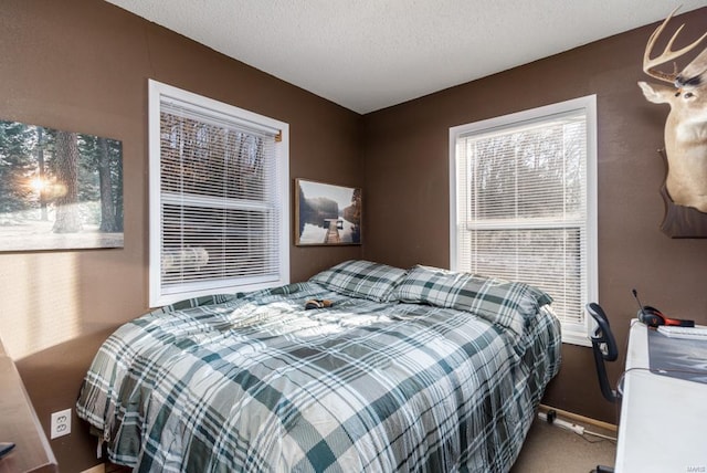 carpeted bedroom featuring baseboards and a textured ceiling