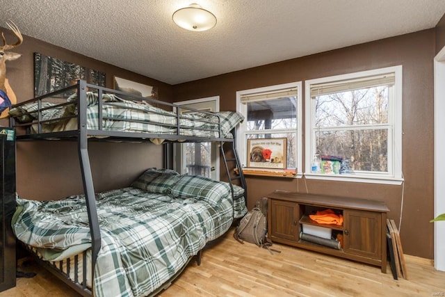 bedroom featuring light wood-type flooring and a textured ceiling