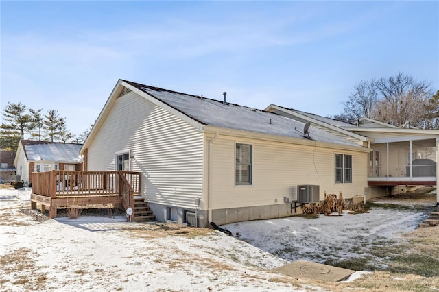 snow covered property featuring a wooden deck and central air condition unit