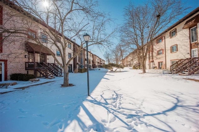 snowy yard featuring a residential view