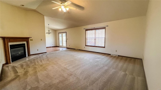 unfurnished living room featuring ceiling fan, light colored carpet, and vaulted ceiling