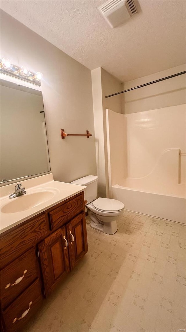 full bathroom featuring bathtub / shower combination, vanity, toilet, and a textured ceiling