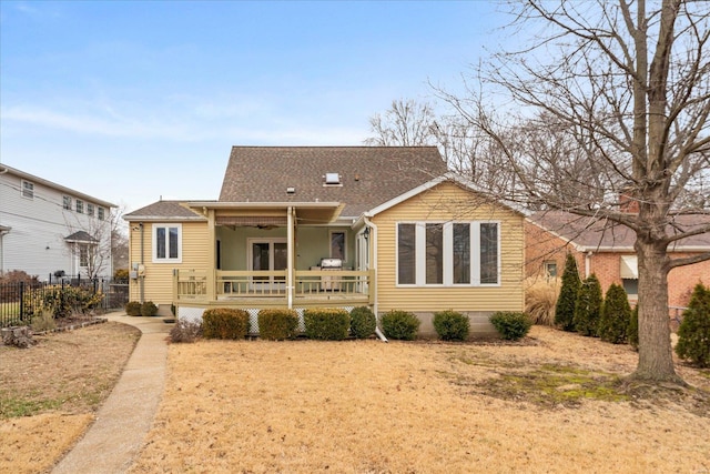 view of front of house with ceiling fan, covered porch, and a front yard