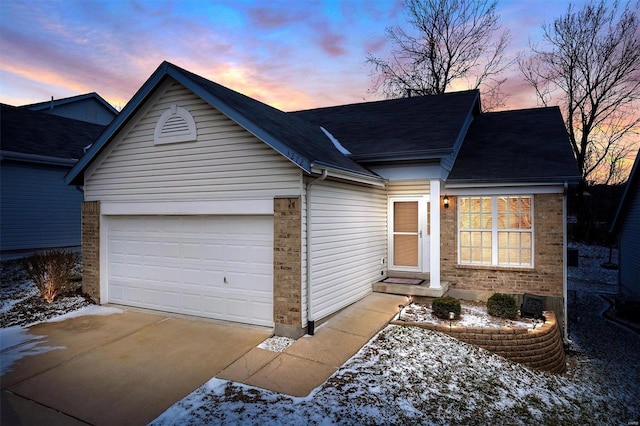 ranch-style house with concrete driveway, brick siding, and an attached garage