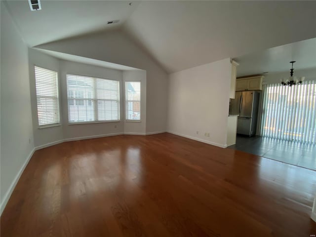 unfurnished living room with lofted ceiling, a chandelier, and dark hardwood / wood-style flooring